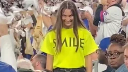 Actriz de la campaña de Smile sonriendo de forma inquietante en las gradas de un estadio